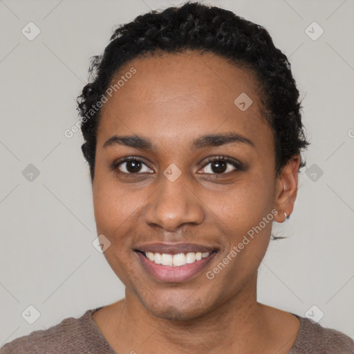 Joyful black young-adult female with short  black hair and brown eyes