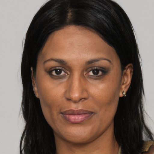 Joyful black adult female with long  brown hair and brown eyes