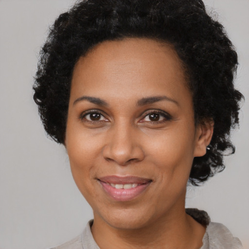 Joyful black adult female with short  brown hair and brown eyes
