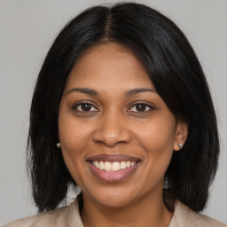 Joyful black young-adult female with long  brown hair and brown eyes