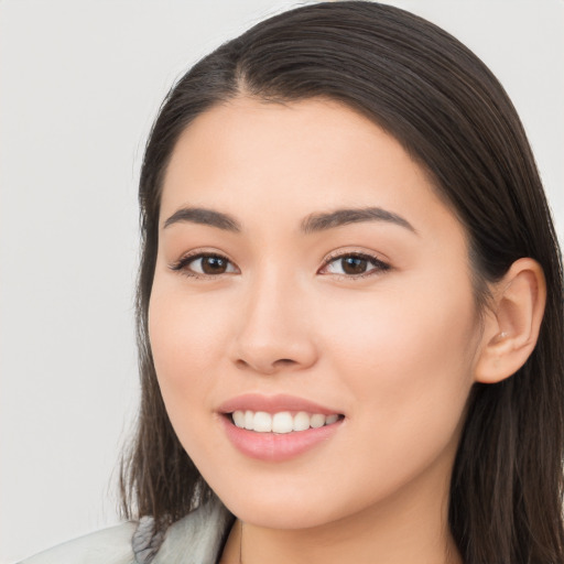 Joyful asian young-adult female with long  brown hair and brown eyes