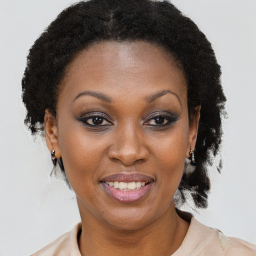 Joyful black adult female with medium  brown hair and brown eyes