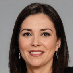 Joyful white adult female with long  brown hair and brown eyes