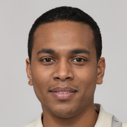 Joyful black young-adult male with short  black hair and brown eyes