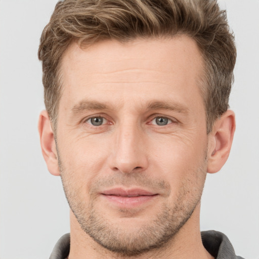 Joyful white adult male with short  brown hair and grey eyes