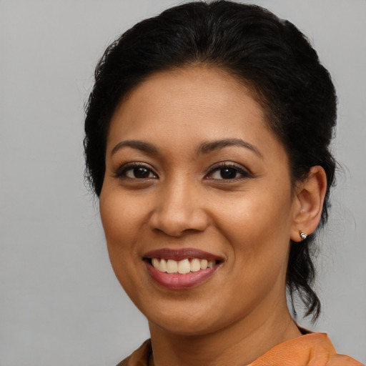 Joyful latino young-adult female with medium  brown hair and brown eyes