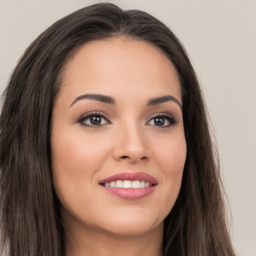 Joyful white young-adult female with long  brown hair and brown eyes