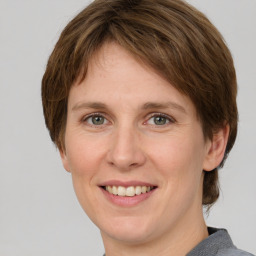 Joyful white adult female with medium  brown hair and grey eyes