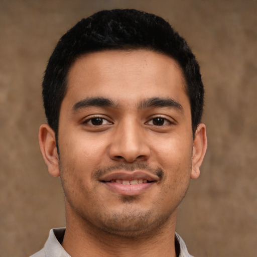 Joyful latino young-adult male with short  black hair and brown eyes