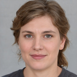 Joyful white young-adult female with medium  brown hair and blue eyes