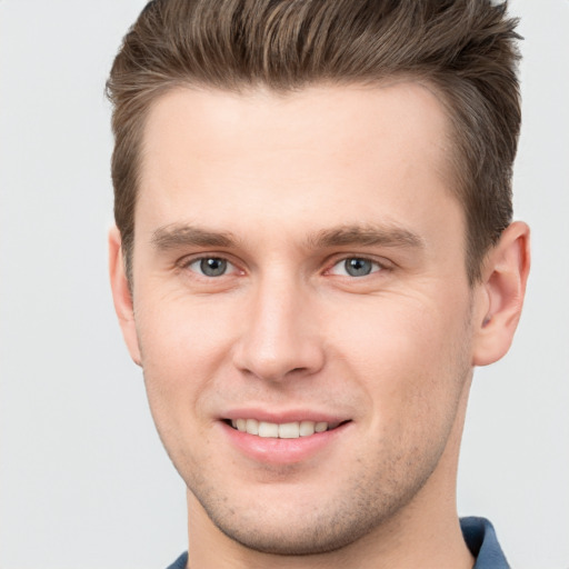 Joyful white young-adult male with short  brown hair and grey eyes