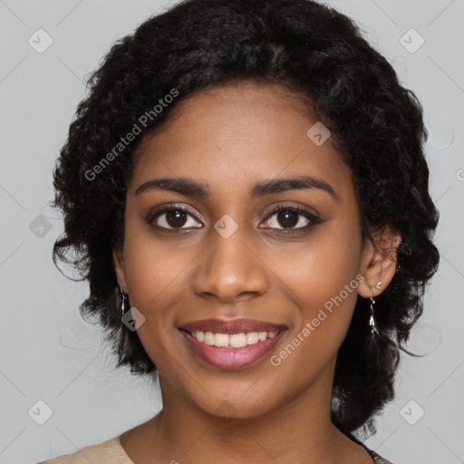 Joyful black young-adult female with long  black hair and brown eyes