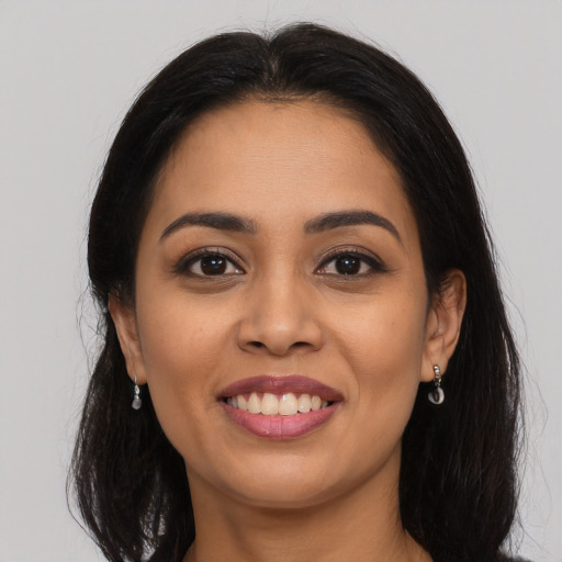 Joyful latino young-adult female with long  brown hair and brown eyes