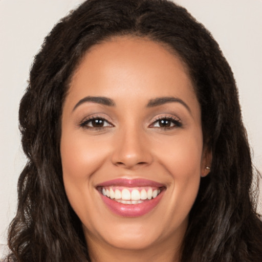 Joyful latino young-adult female with long  brown hair and brown eyes