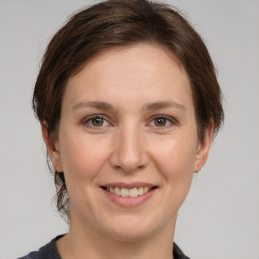 Joyful white young-adult female with medium  brown hair and grey eyes