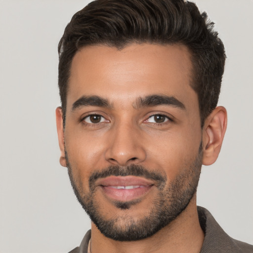 Joyful white young-adult male with short  black hair and brown eyes