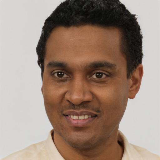 Joyful black young-adult male with short  black hair and brown eyes