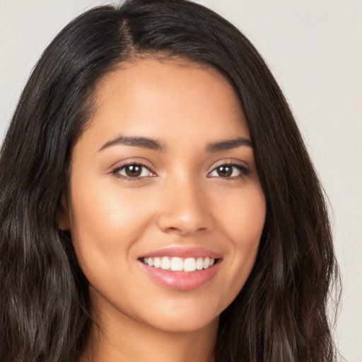 Joyful latino young-adult female with long  brown hair and brown eyes