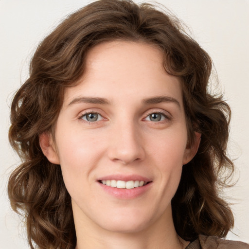 Joyful white young-adult female with long  brown hair and blue eyes