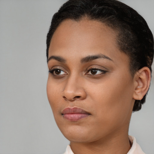 Joyful black young-adult female with short  black hair and brown eyes