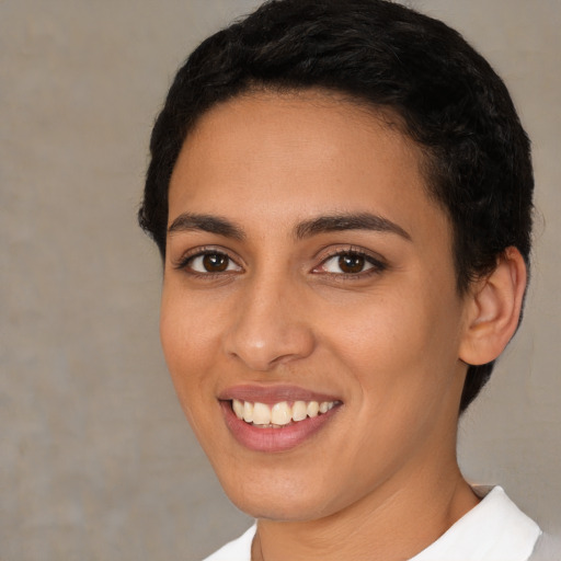 Joyful latino young-adult female with short  black hair and brown eyes