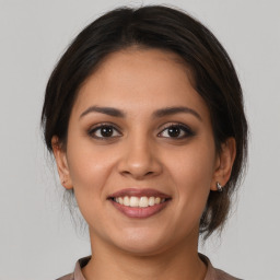 Joyful latino young-adult female with medium  brown hair and brown eyes