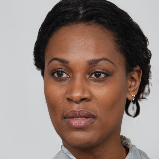 Joyful black adult female with short  black hair and brown eyes