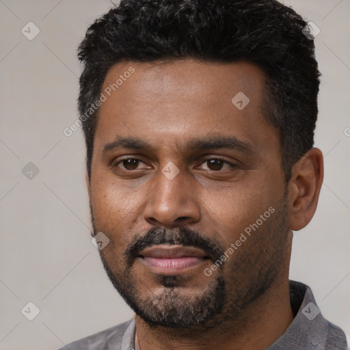 Joyful black young-adult male with short  black hair and brown eyes