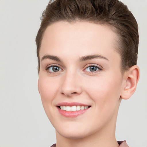 Joyful white young-adult female with short  brown hair and grey eyes