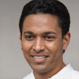 Joyful latino young-adult male with short  black hair and brown eyes