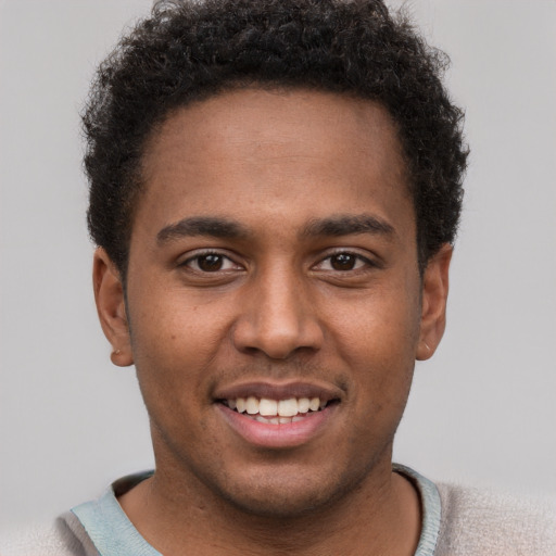 Joyful black young-adult male with short  brown hair and brown eyes