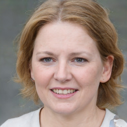 Joyful white adult female with medium  brown hair and grey eyes