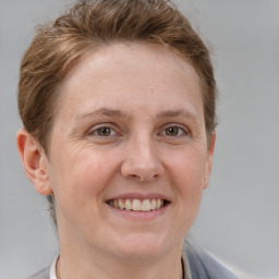 Joyful white young-adult female with short  brown hair and grey eyes