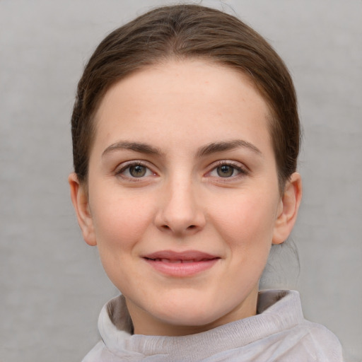 Joyful white young-adult female with short  brown hair and grey eyes