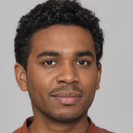 Joyful black young-adult male with short  black hair and brown eyes