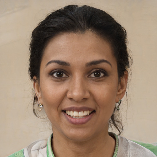 Joyful black young-adult female with medium  brown hair and brown eyes