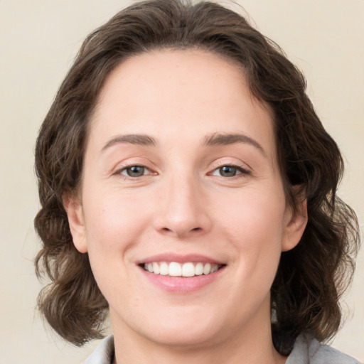 Joyful white young-adult female with medium  brown hair and green eyes