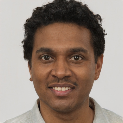 Joyful black young-adult male with short  black hair and brown eyes