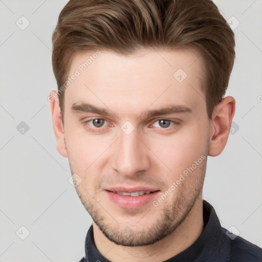 Joyful white young-adult male with short  brown hair and grey eyes