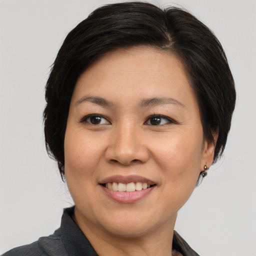 Joyful asian adult female with medium  brown hair and brown eyes