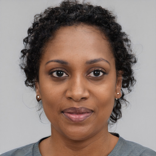 Joyful black young-adult female with medium  black hair and brown eyes