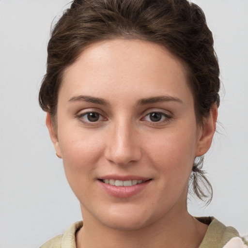 Joyful white young-adult female with medium  brown hair and grey eyes