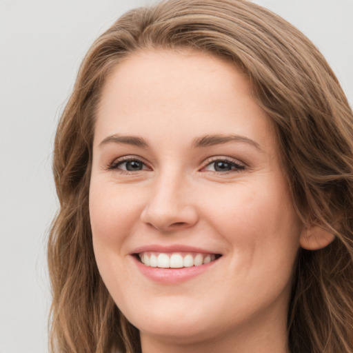 Joyful white young-adult female with long  brown hair and green eyes