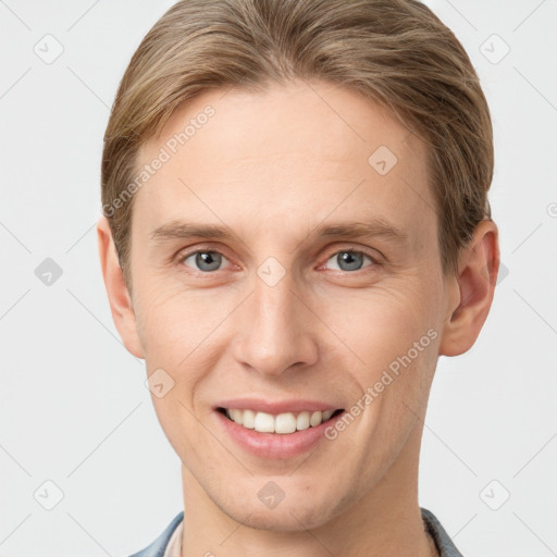 Joyful white young-adult male with short  brown hair and grey eyes