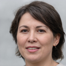 Joyful white adult female with medium  brown hair and brown eyes