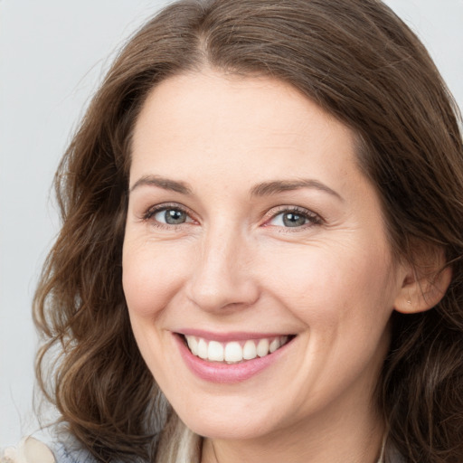 Joyful white young-adult female with long  brown hair and grey eyes