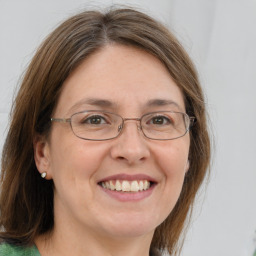 Joyful white adult female with medium  brown hair and green eyes