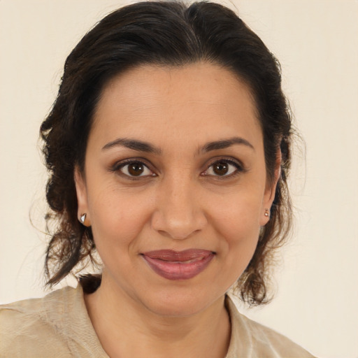 Joyful latino adult female with medium  brown hair and brown eyes
