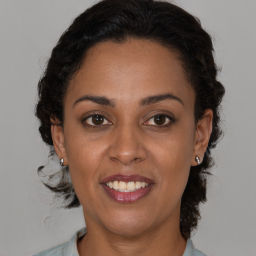 Joyful black young-adult female with medium  brown hair and brown eyes