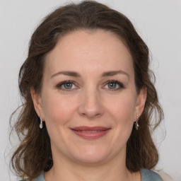 Joyful white adult female with medium  brown hair and grey eyes